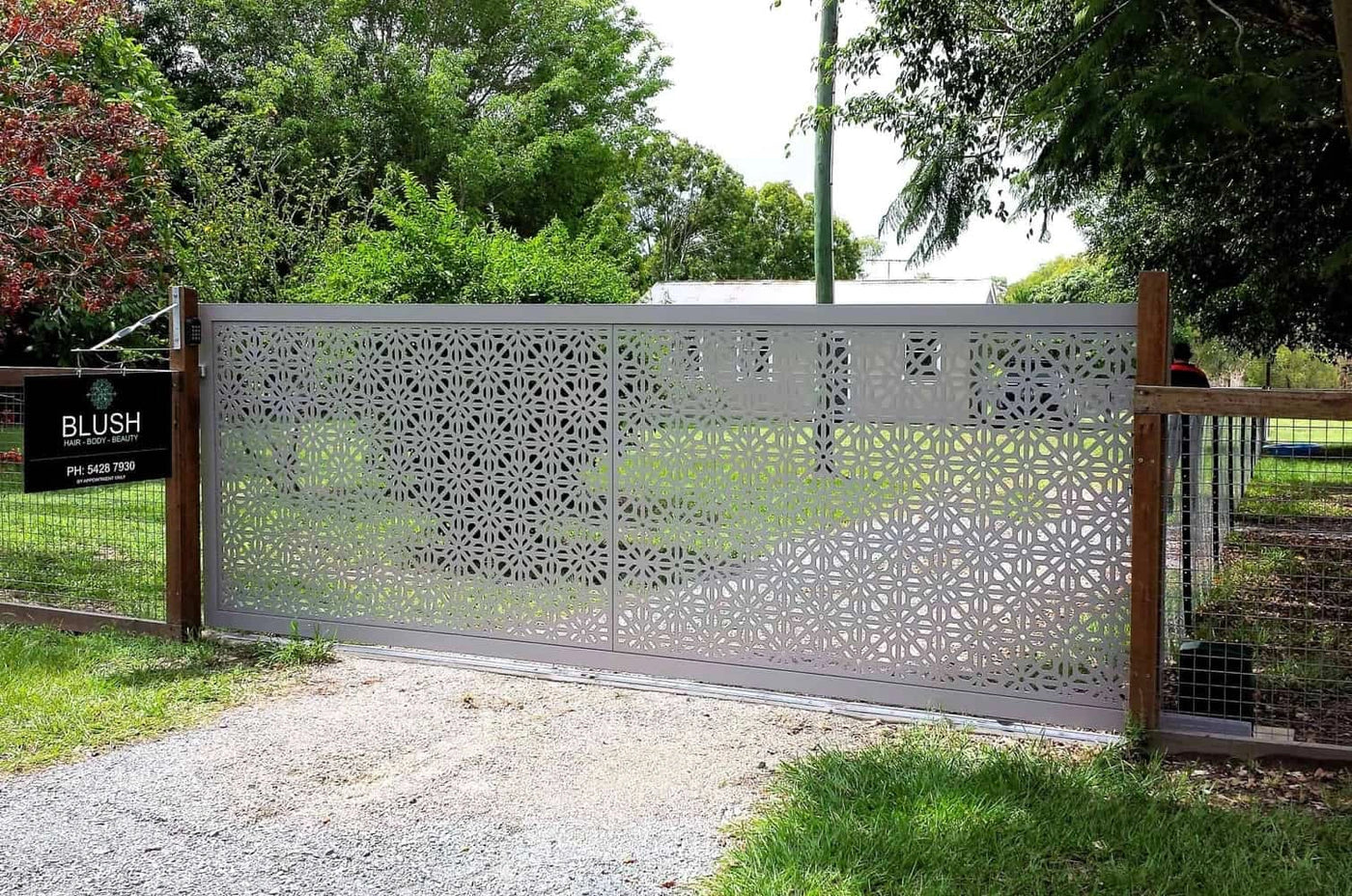 Architectural exterior metal screen defining an open outdoor boundary around a commercial landscape.