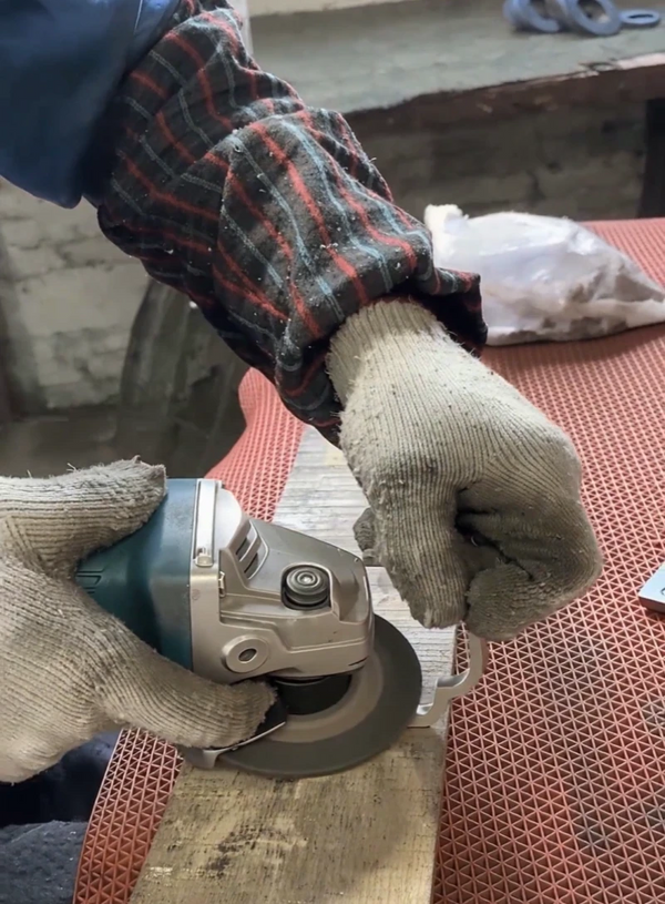 Skilled metal worker hand-polishing stainless steel screen frames to a hairline finish.