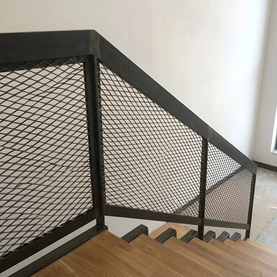 Expanded metal mesh infill in a blackened steel stair balustrade over timber treads — visualization