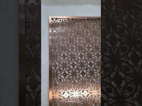 Hotel lobby with stainless steel feature wall in champagne PVD finish, walnut and marble palette.